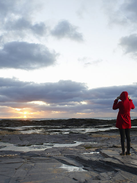 woman overlooking rocky shoreline